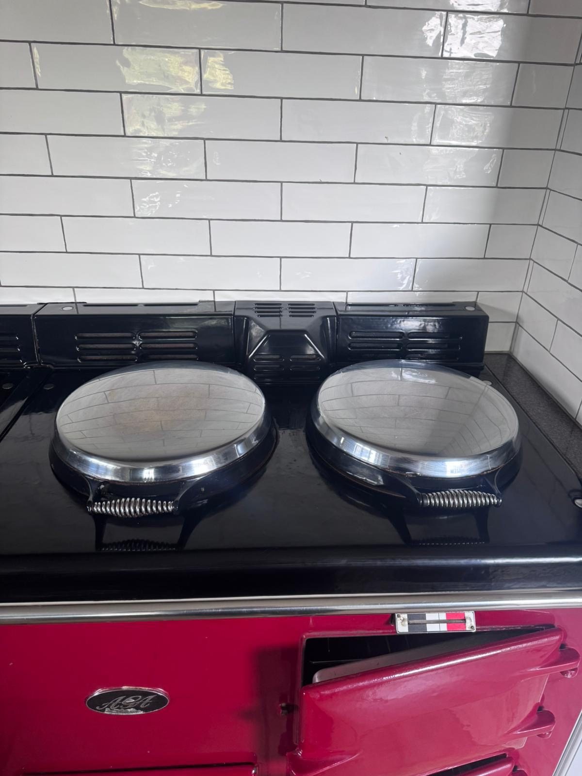 A gleaming red AGA range cooker cleaned by Pure Luxe