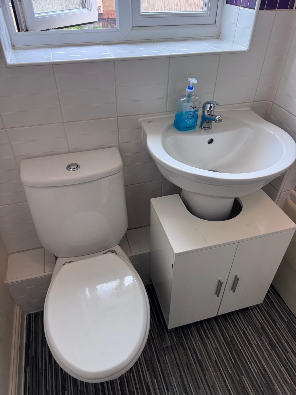 Sparkling clean bathroom with a fresh white suite and tiled floor