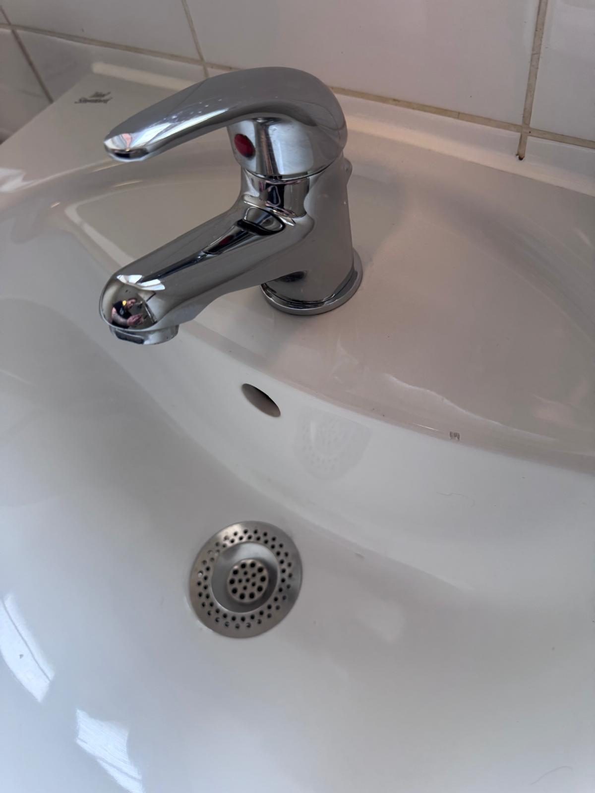 Close-up of a gleaming polished chrome faucet — Pure Luxe's signature attention to detail